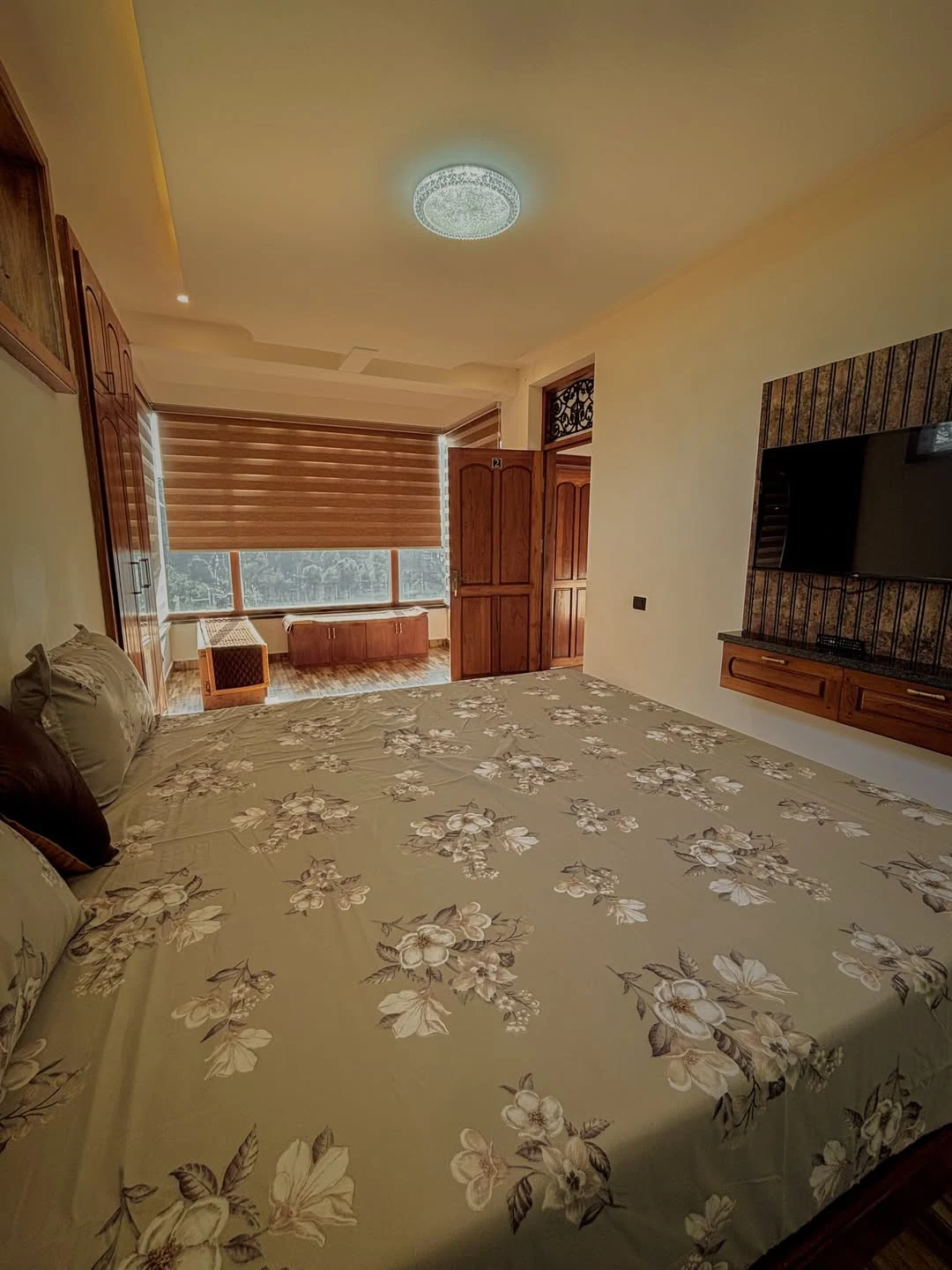 Double room with white linen bed and wooden paneled wall
